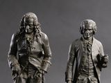 two statues of a man and a woman standing next to each other