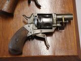 a revolver and a gun on a wooden table