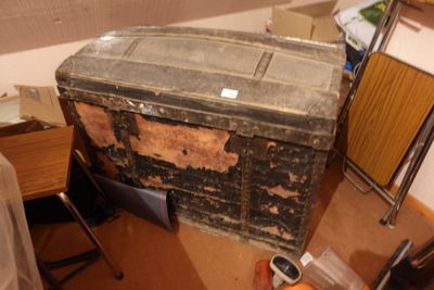 une vieille malle posée dans un coin de la pièce