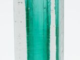 a green glass vase with water in it on a white surface