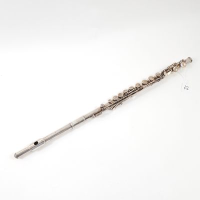 an old silver flute on a white surface with a white background