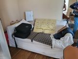 a man standing in a room with a bed and suitcases