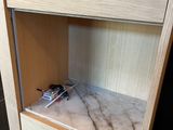 a marble counter top with a wooden cabinet and a phone on it