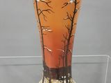 un vase en verre sur lequel est représentée une forêt