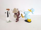 three figurines of donald duck and daisy duck on a white surface