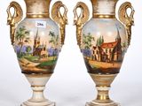 pair of antique vases with a painting of a church on them