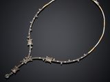 a gold and silver necklace with stars on a black background