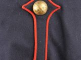 the back of a military uniform with a gold button on it