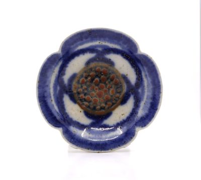 a small blue and white plate with a flower on it