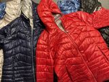several jackets are lined up on a rack in a store
