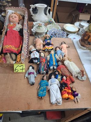une table sur laquelle sont posées de nombreuses poupées et d'autres objets
