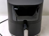 a black air fryer sitting on a white table