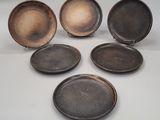 quatre plaques métalliques de tailles différentes disposées les unes à côté des autres sur une surface blanche