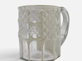 a glass cup with a handle on a white surface