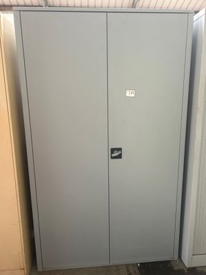 une armoire métallique placée dans un coin de la pièce, près d'une porte