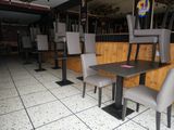 tables and chairs in a restaurant with wooden walls and tile flooring