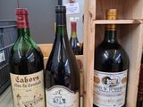 trois bouteilles de vin dans une caisse en bois posée sur un comptoir