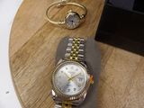 a watch and a bracelet on a wooden table