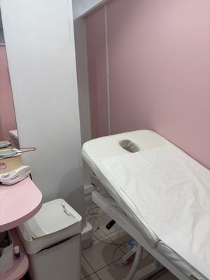 un lit dans une chambre aux murs roses et avec une table rose