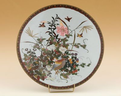 une assiette décorative ornée d'un oiseau et de fleurs
