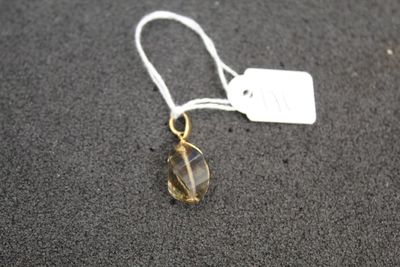 a close up of a yellow glass bead on a white string