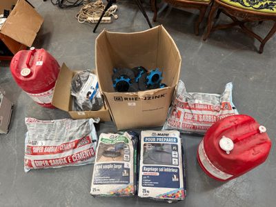 une boîte contenant divers objets posée par terre à côté d'une borne d'incendie