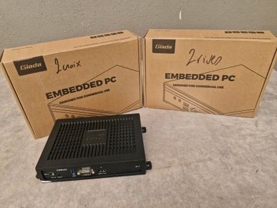 deux cartons contenant du matériel informatique posés l'un à côté de l'autre sur un lit