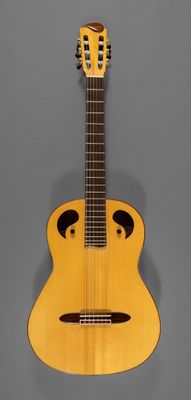 un gros plan d'une guitare sur fond gris