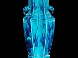 un vase bleu posé sur une surface noire