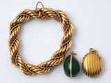 deux bijoux dorés et verts posés sur une surface blanche