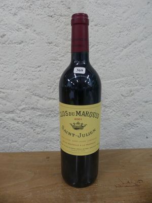 une bouteille de vin rouge posée sur une table en bois