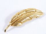 une broche en feuille d'or sur un fond blanc