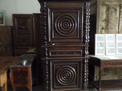 a tall wooden cabinet in the middle of a room