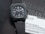 une montre noire posée sur une feuille de papier