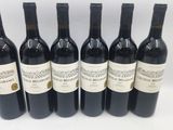 six bouteilles de vin sont alignées sur une table