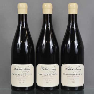 three bottles of wine are lined up on a table