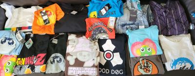 a lot of t - shirts that are sitting on a couch