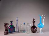 a lot of glass bottles and vases on the table
