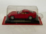 a red toy car in a clear case on a table