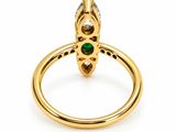 a close up of a gold ring with a green stone