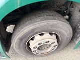 a green truck that has a flat tire on it