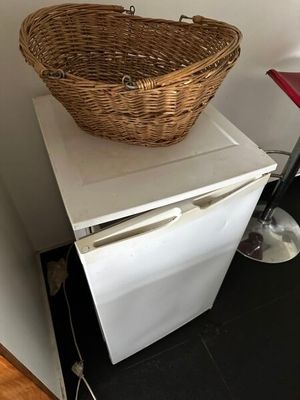un panier en osier posé sur un petit réfrigérateur