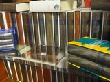 une étagère en verre sur laquelle sont posés tout un tas de livres