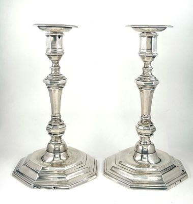 une paire de bougeoirs en argent sur fond blanc, avec un fond blanc
