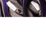 the inside of a purple purse with a tag on it