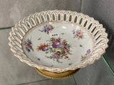 a bowl with flowers on it sitting on a shelf