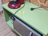 a green shelf with a microwave and a red coffee maker on it