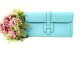 blue leather clutch bag with flower on white background