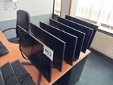 a desk with a bunch of computer monitors and keyboards on it