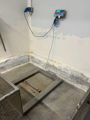 une petite pièce avec un sol en métal et un téléphone accroché au mur